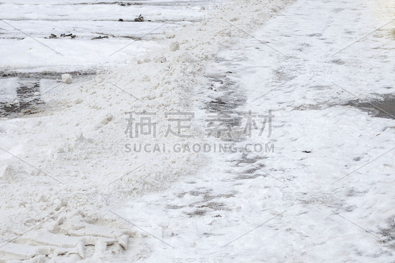 冬天，白雪覆盖的道路上撒满了沙子。