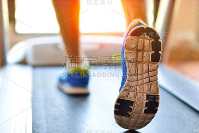 在健身房跑步机上跑步的男人