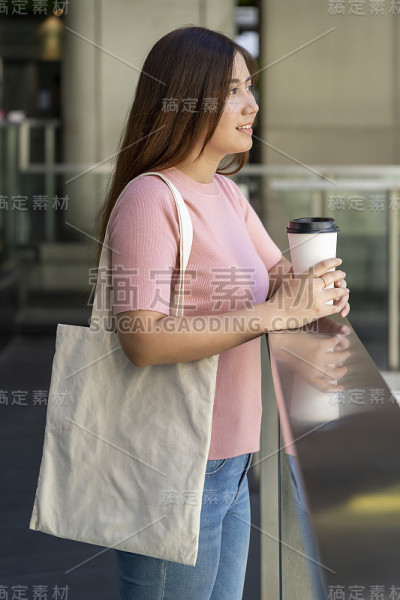年轻漂亮的女人拿着一个白色的帆布包