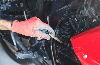 机械师检查摩托车机油位。