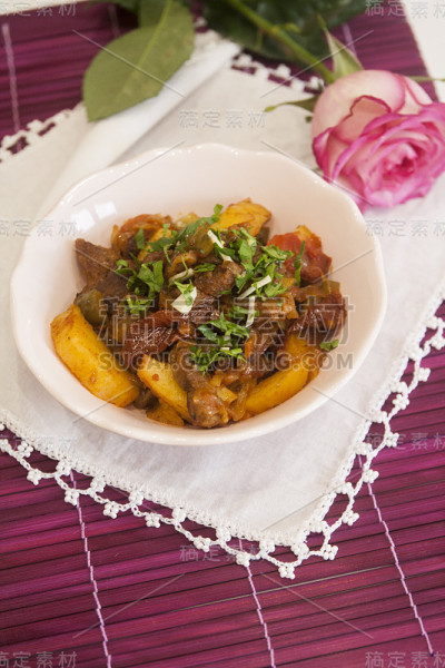 肉炖土豆和香料，西红柿，黄瓜和绿色蔬菜。菜炖牛肉