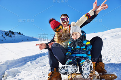 快乐的一家人在冬天的树林里坐雪橇，欢快的冬季娱乐
