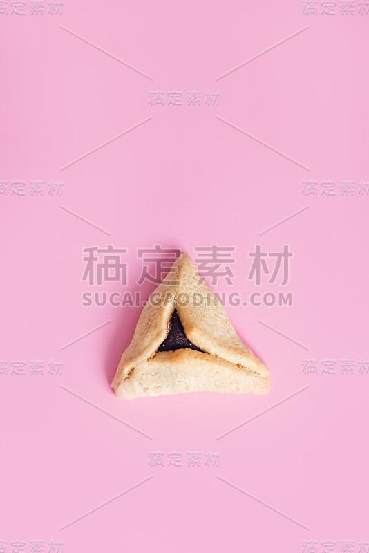 一个Hamentashen, Ozen Haman，犹太节日普林节的粉色背景上的普林节饼干