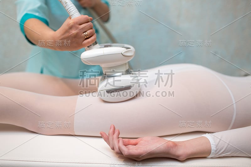 年轻美丽的女人和LPG按摩背部程序在水疗诊所