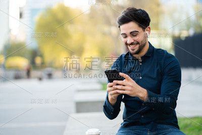 一个年轻人在户外用手机。