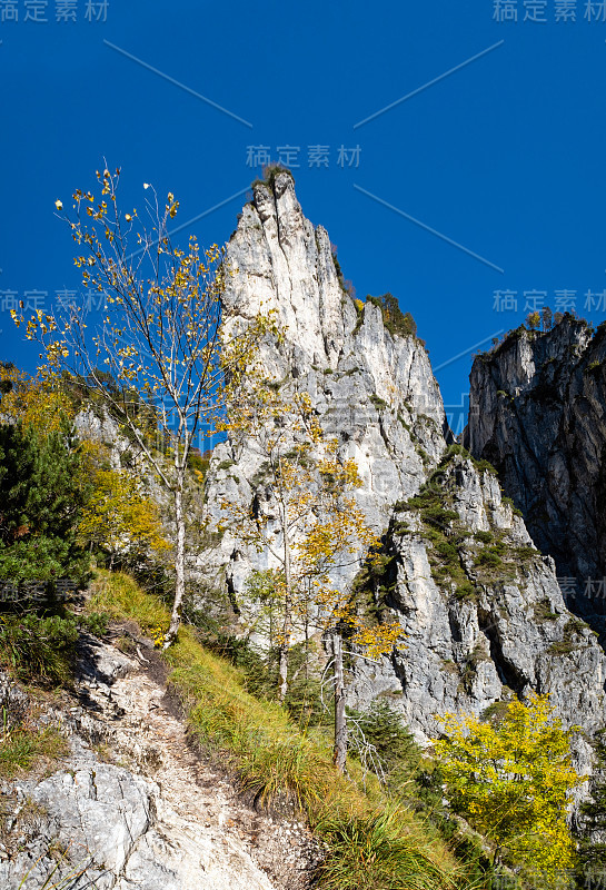 阳光灿烂的高山秋景。上奥地利阿尔姆西湖附近徒步旅行的宁静岩石山景。