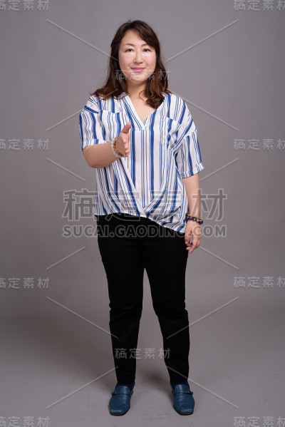 工作室拍摄的成熟美丽的亚洲女商人在灰色的背景
