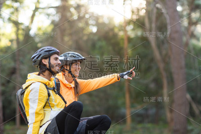 一对骑自行车的夫妇坐着，指着远方
