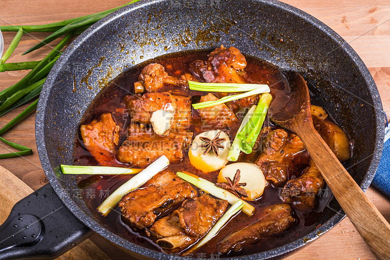 中国红烧排骨。用红辣酱在平底锅里炖猪肉，胸肉和排骨，特写-加勒比，中国，亚洲风格