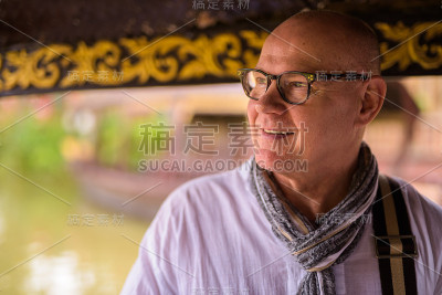 斯堪的纳维亚高级游客男子度假在大城府前暹罗泰国的首都，而与河的士船旅行