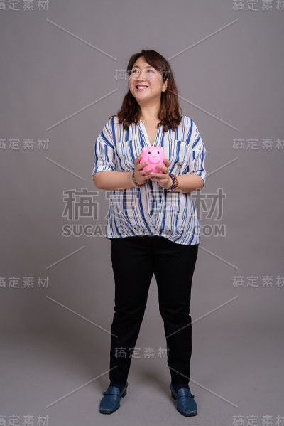 工作室拍摄的成熟美丽的亚洲女商人在灰色的背景