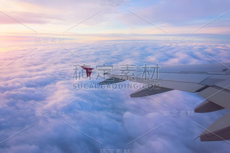 日出时清晨天空中的飞机机翼视图。