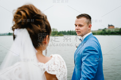 新郎在湖边看着新娘。