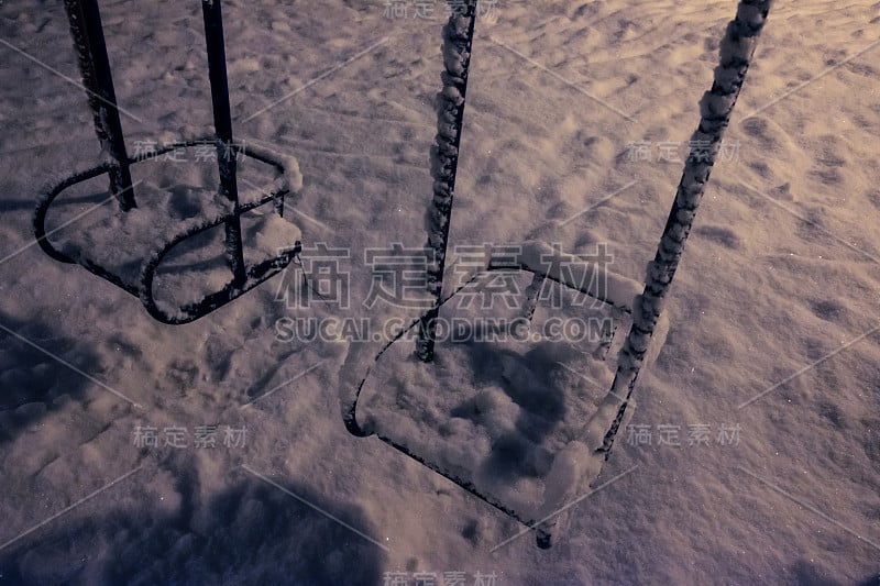 操场上的秋千上覆盖着新雪