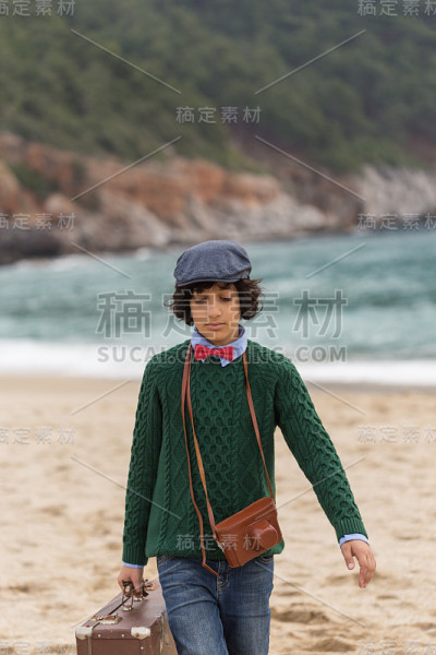 带着老式相机和行李箱的旅行男孩