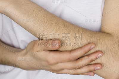 穿着白衬衫的年轻女子抚摸着自己的手