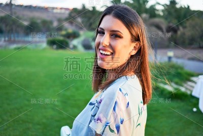 年轻美丽和优雅的女人与婚礼的客人服装微笑快乐和愉快