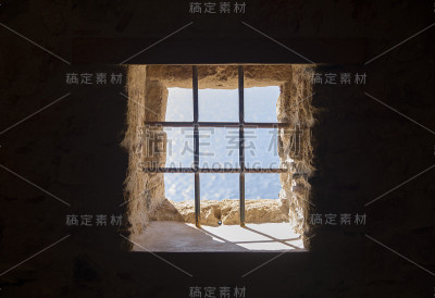 希腊古老的带有金属格栅的石头窗户
