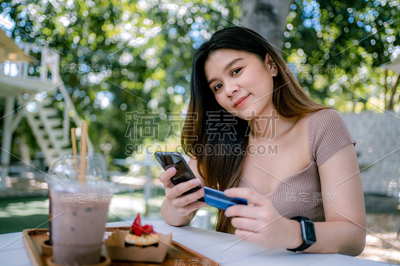 美丽微笑的年轻亚洲女性管理网上银行与手机应用程序在智能手机上，并进行移动支付与信用卡。