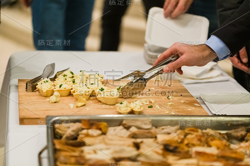 男人在餐桌上选择美味的庆祝小吃。