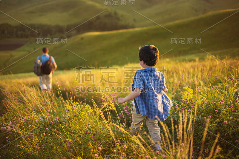 小男孩跟着他的父亲在地里干活