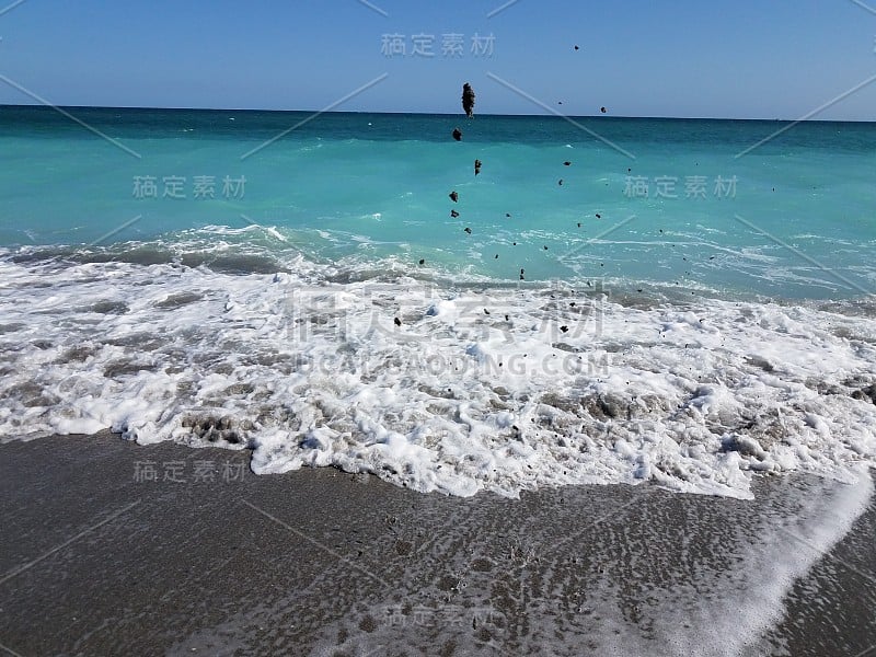 海浪把沙子抛向沙滩的空中