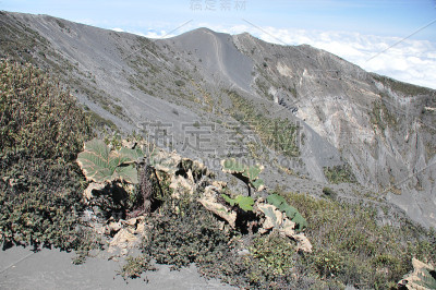 哥斯达黎加的伊拉祖火山。有防护屏障的云层中的火山口。熔岩和浮石的碎片。