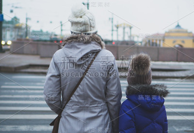 母女俩过马路。后视图。