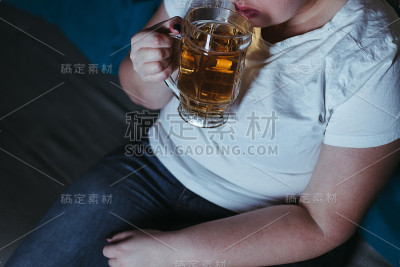 孤独的女人看电视喝啤酒