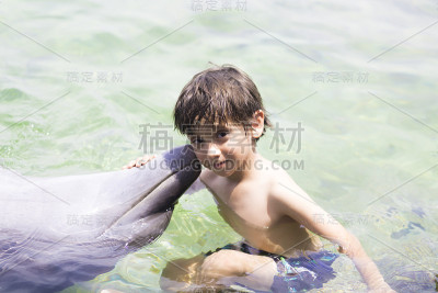 假期生活方式-快乐男孩拥抱海豚