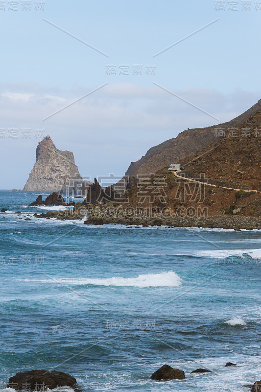 海岸线上遥远的公路紧挨着海滩，海浪汹涌