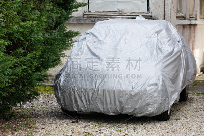 汽车用银色保护罩停在自家花园里
