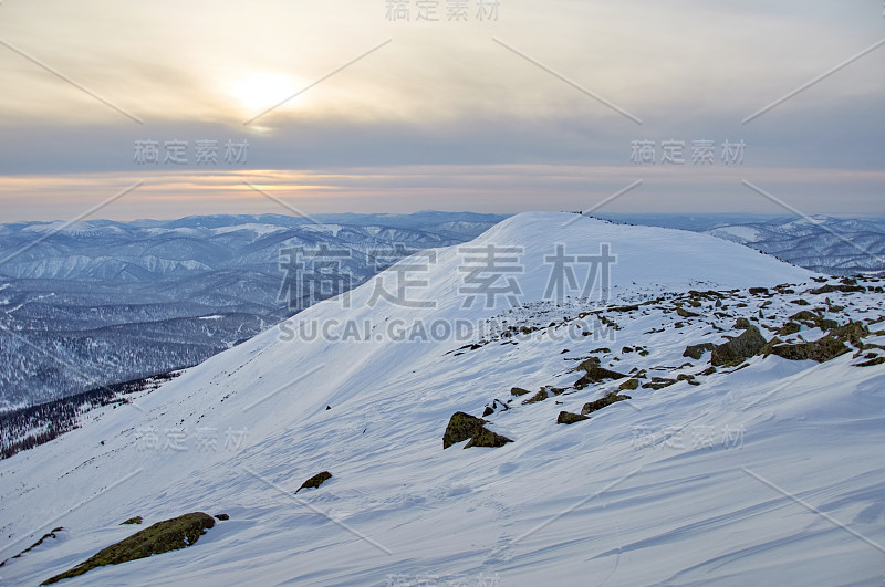 白雪皑皑的山峰映衬着连绵的山脉。徒步登山。