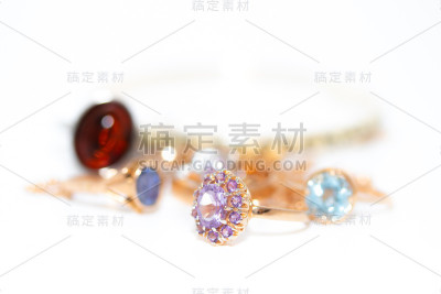 收藏珠宝与美丽的黄金戒指与紫色的石头孤立在白色的背景