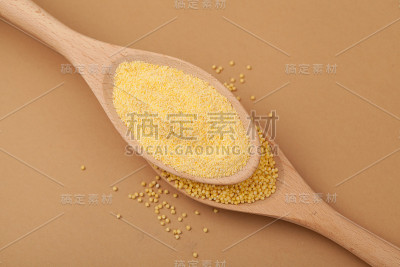 小米粉和谷粒放在木勺上，特写。俯视图，选择焦点，复制空间
