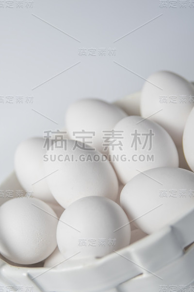 白色的鸡蛋在陶瓷白色的公司在白色的背景