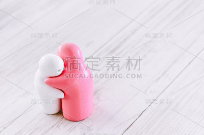 白色和粉红色的陶瓷娃娃在木头上