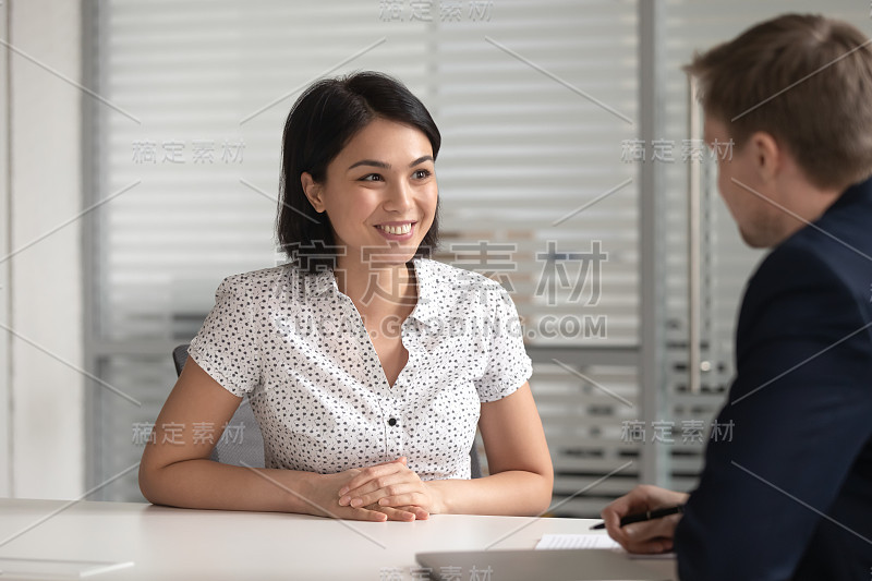 快乐的亚洲女性候选人在工作面试与人力资源经理。