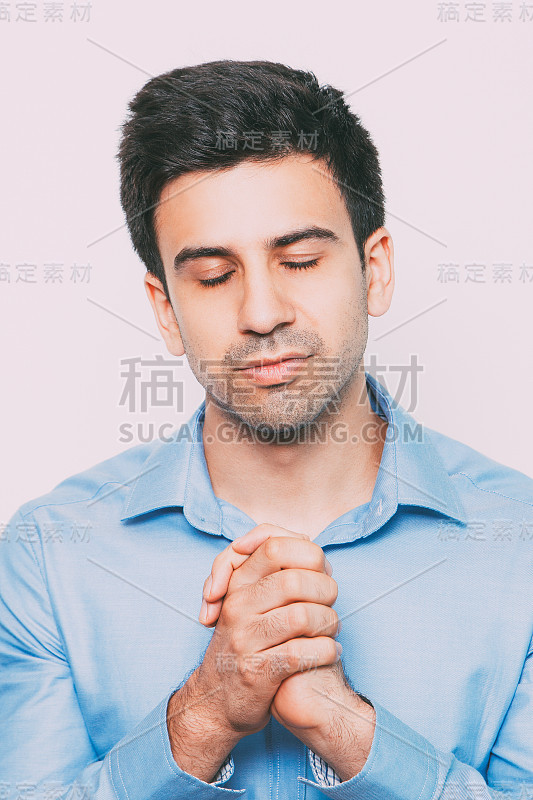 英俊的男人集中与紧握的双手