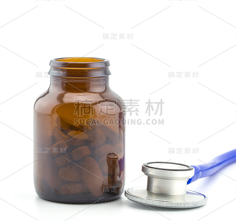 医用听诊器头与一堆药丸特写。保健、健康