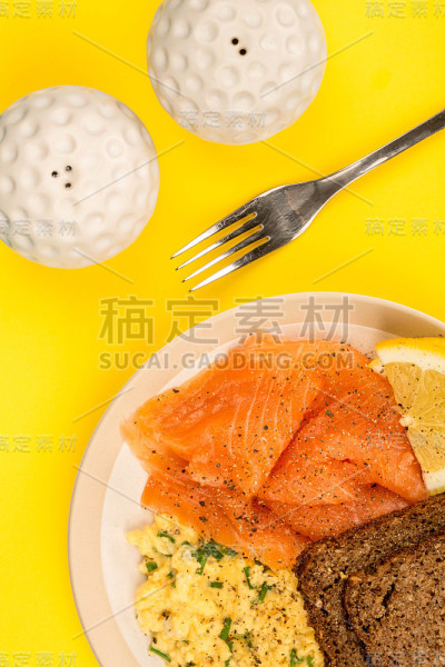 烟熏三文鱼炒蛋配黑麦面包和柠檬斯堪的纳维亚式早餐