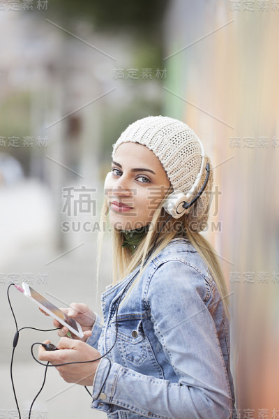 戴着耳机拥抱阳光的迷人女孩