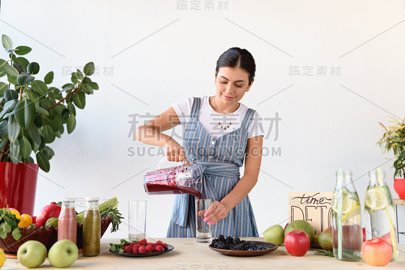 往玻璃杯里倒解毒饮料的女人