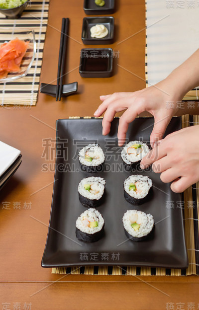 女厨师将日本寿司卷放在托盘上