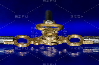 三个古董黄铜怀表钥匙放置在蓝色表面