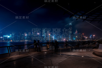 香港城市夜景。在海滨散步的游客