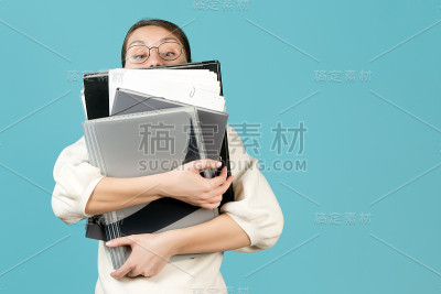 一个年轻女子和大量的工作文件