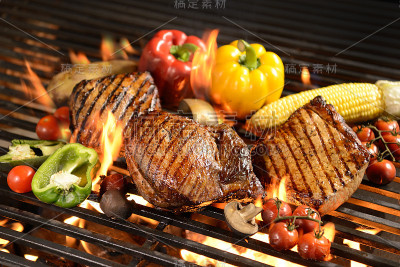 在燃烧的烤架上烤肉/牛排配蔬菜