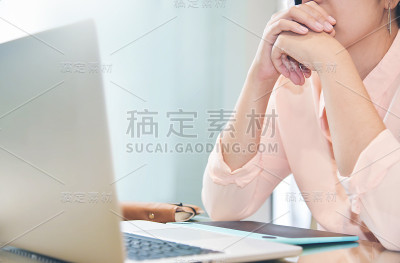 女性创意设计师思考和工作与笔记本电脑。