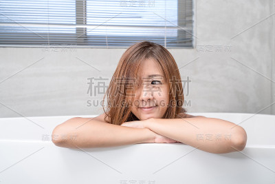 年轻迷人的亚洲女孩在浴室里用蜡烛洗澡放松。美容院的女人。健康完美容光焕发的护肤理念